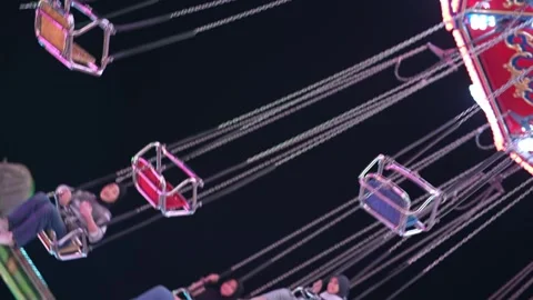 Slowmo swing ride chairs rotating above fairground at night Stock-Footage 332739685