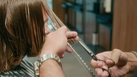 Slowmo of Tattooed Hands of Skillful Barber Tapering Male Clients Hair 動画素材 317541389