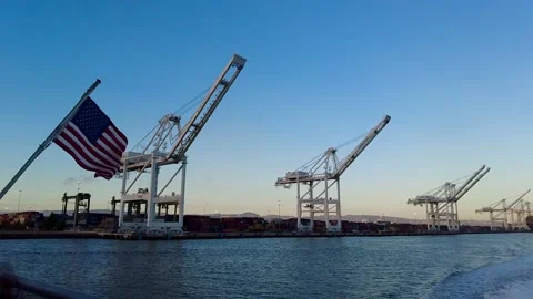 Slowmotion of American Flag waving in front of Port of Oakland Cargo Cranes Stock Footage 199095912