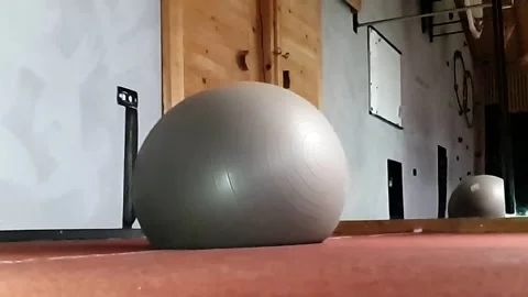 A slowmotion of a big pilates ball falling on a floor at a gym Stock Footage 143396824
