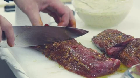 Slowmotion. Close-up of a chef cut up the meat Stock Footage 68927086