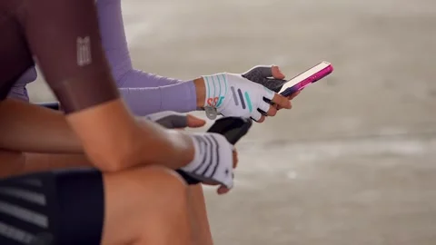 Slowmotion closeup of cyclists resting and holding a smartphone. Sporting gloves Stock Footage 308880230