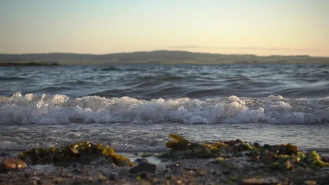 Slowmotion closeup of waves lapping against the beach Stock Footage 137431133