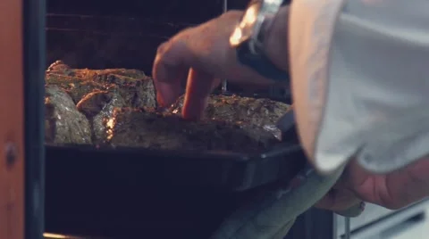 Slowmotion. Cook put the pan with the meat in the oven Video stock 68927936