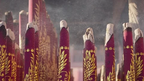 Slowmotion of dense white smoke curling from tall red incense sticks in a temple Stock Footage 312278419