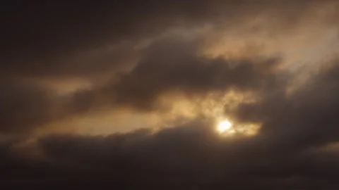 Slowmotion of dramatic clouds glowing at sunset in moody golden sky Stock Footage 313950346
