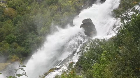 Slowmotion of Dramatic waterfall cascades over rocky cliffs in the daytime in 4K Stock Footage 322827352