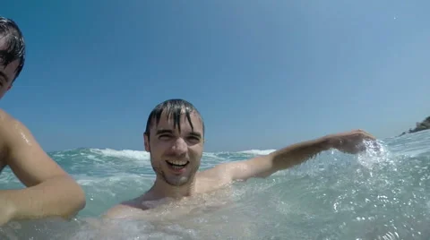Slowmotion of ecstatic men in sea waves 動画素材 68913419