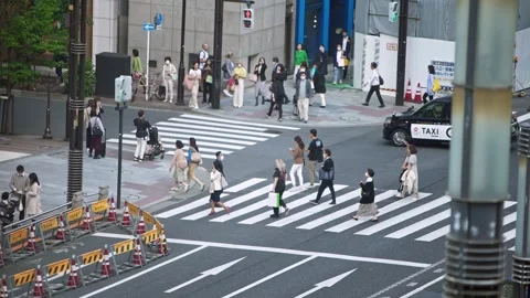 Slowmotion elevated view of Japanese people crossing a pedestrian crossing zone. Stock Footage 308879464