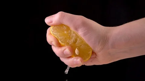 Slowmotion lemon. The hand squeezes of lemon juice Stock Footage 122941883
