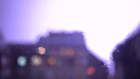 SlowMotion lightning with rain on the window with blury background lights Stock Footage 161757924