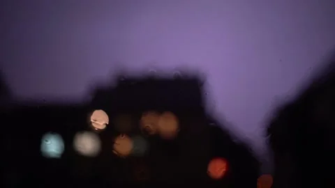 SlowMotion lightning with rain on the window with blury background lights Stock Footage 161757933