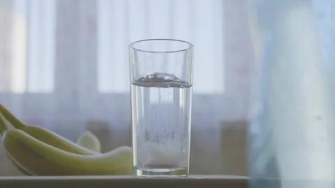 Slowmotion log sparkling vitamin pill drops in glass of water Stock Footage 203882397