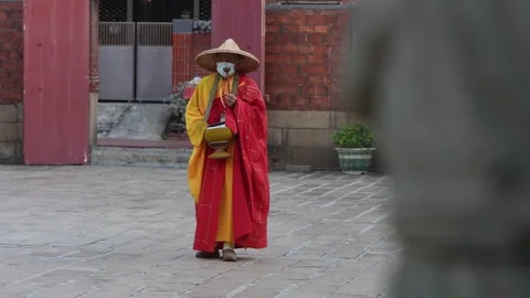 Slowmotion of monk completing temple mantra walk with offering bowl and bell Stock Footage 315061983