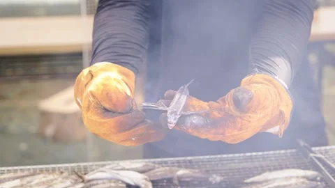 Slowmotion of multiple barbecues filled with fish grilling outdoors Japan Stock Footage 321296079
