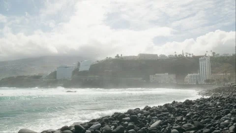 Slowmotion ocean waves crushing on pebble beach, tandem paragliding above 库存影片 271475936