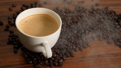 Slowmotion Pan shot of coffee cup surrounded by coffee beans Stock Footage 109403331