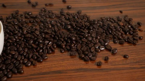 Slowmotion Pan shot of coffee cup surrounded by coffee beans Stock Footage 109403406