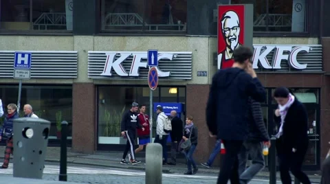 Slowmotion people walk on sidewalk in front of KFC shop. Vídeo Stock 60052073
