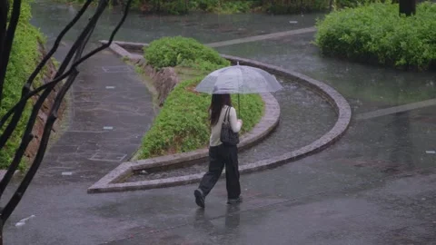 Slowmotion of people walking with umbrellas through curved walkway in rain Japan Stock Footage 321144288