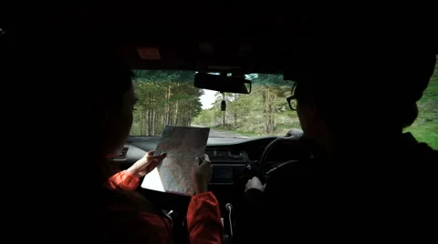 Slowmotion. Rear view shot of a young couple on road trip reading a map Stock Footage 63371609
