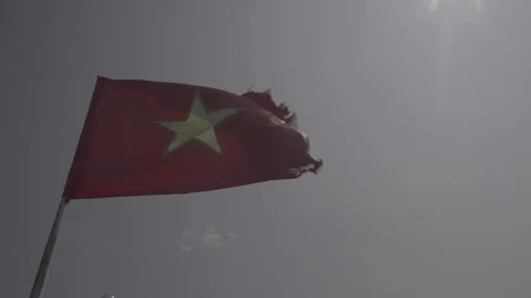 Slowmotion shot of a broken Vietnamese flag waving in the wind against the Stock Footage 240983054