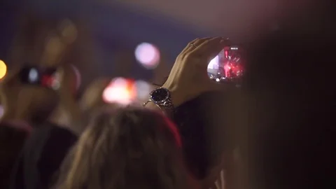 Slowmotion shot of a concert. Woman shoots video on her cell phone. Stock Footage