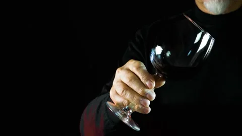 Slowmotion shot of hand with red wine in crystal clear wine glass Stock Footage 136962017