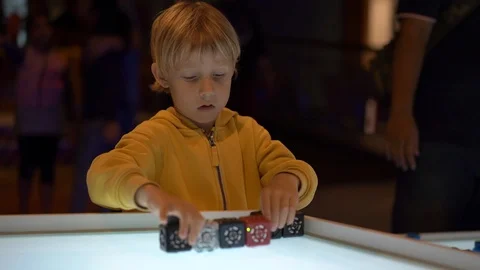 Slowmotion shot of a little boy visiting a science museum for children. He plays Stock Footage 102486859