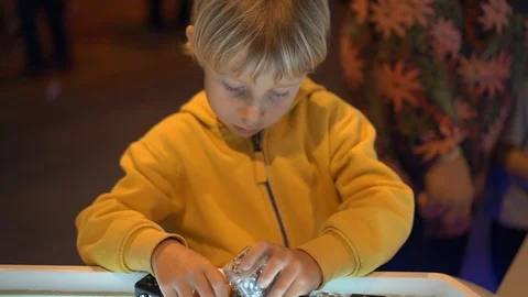 Slowmotion shot of a little boy visiting a science museum for children. He plays Stock Footage 102488278