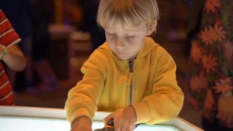 Slowmotion shot of a little boy visiting a science museum for children. He plays Stock Footage 102489460
