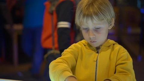 Slowmotion shot of a little boy visiting a science museum for children. He plays Stock Footage 102490256