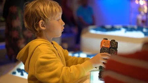 Slowmotion shot of a little boy visiting a science museum for children. He plays Stock Footage 102491040