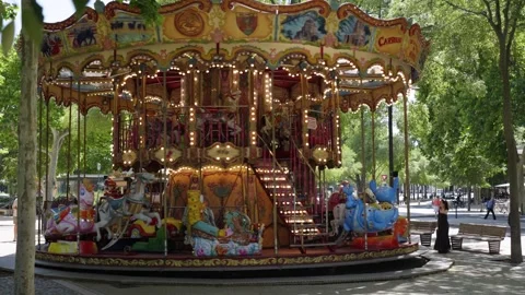 Slowmotion shot of a merry-go-round turning with tourists staring in Montpellier Stock-Footage 314888028
