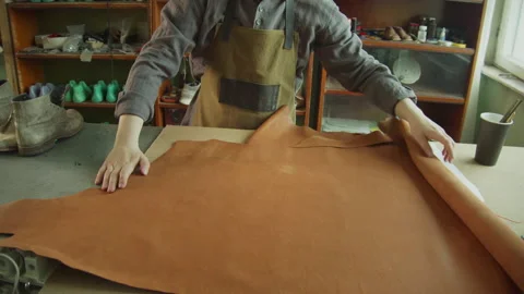 Slowmotion shot. The tailor bought a large roll of genuine leather for his Stock Footage 143724227