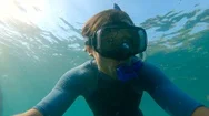 Slowmotion Shot Of A Young Man Snorkeling And Diving Dip Into Sea. U.p.f 50 On A Stock Footage