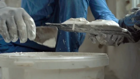 Slowmotion shot of a young painter applying putty on the walls Stock Footage 95490016