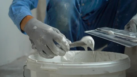 Slowmotion shot of a young painter applying putty on the walls Stock Footage 95490027