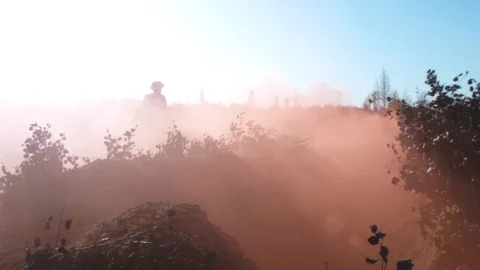 Slowmotion of silhouettes of military men running on field in smoke and falling Stock Footage