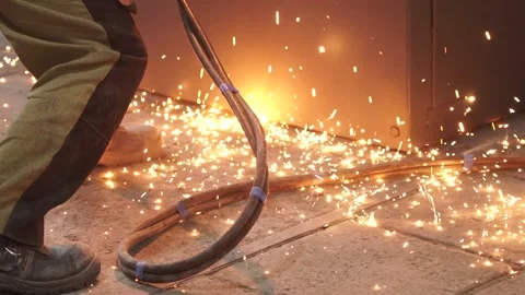 Slowmotion. Sparks from welding fall to the floor. Sparks, man's legs and wires. Stock Footage 196879529