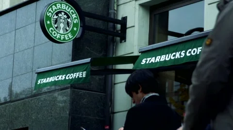 Slowmotion view on shop of Stabucks coffee on street where pass people Stock-Footage 60051960
