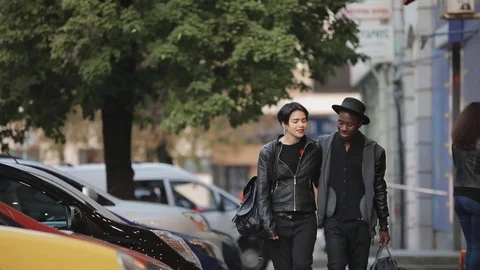 Slowmotion of white woman and black man walking together. Couple dating, they Stock Footage