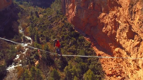 Slowmotion with a young brave man slacklining , highlining above a big canyon Stock Footage 85261692