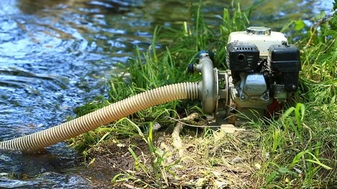 Sluice Box Pump and Generator Sitting on River Bank at Gold Panning Claim Stock Footage 114795084