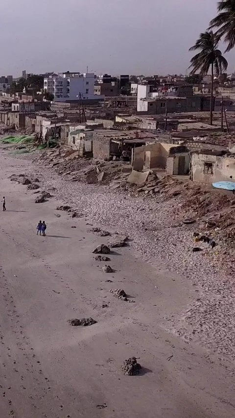 Slums built along sandy beach, city buildings in background Stock Footage 230673046
