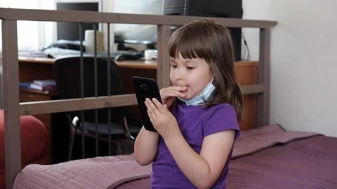 A small 4-year-old child plays video games on a smart phone. Stock Footage 133218192