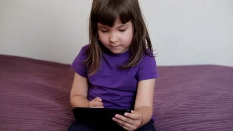 A small 4-year-old child plays video games on a smart phone. Stock Footage 133218211