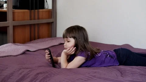 A small 4-year-old child plays video games on a smart phone. Stock Footage 133218252