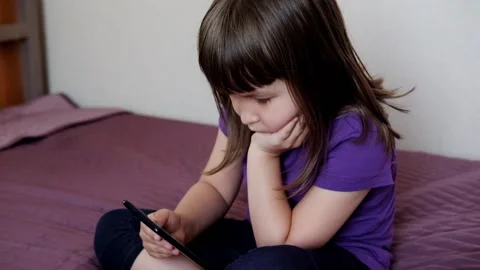 A small 4-year-old child plays video games on a smart phone. Stock Footage 133218344
