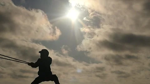 Small 5 years old boy pulling rope silhouette slow motion - strong character Stock Footage 197425015